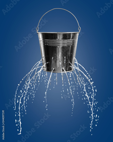Leaky bucket with water on blue background