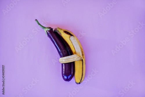 Banana hugs an eggplant with peel.