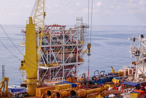 Large work barge carrying new structure module to be installed at oil and gas platform at offshore.