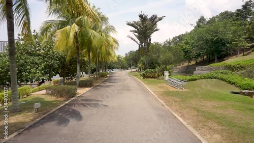 Smooth point of view (POV) footage on a jogging track in a beautiful public park in a sunny day.