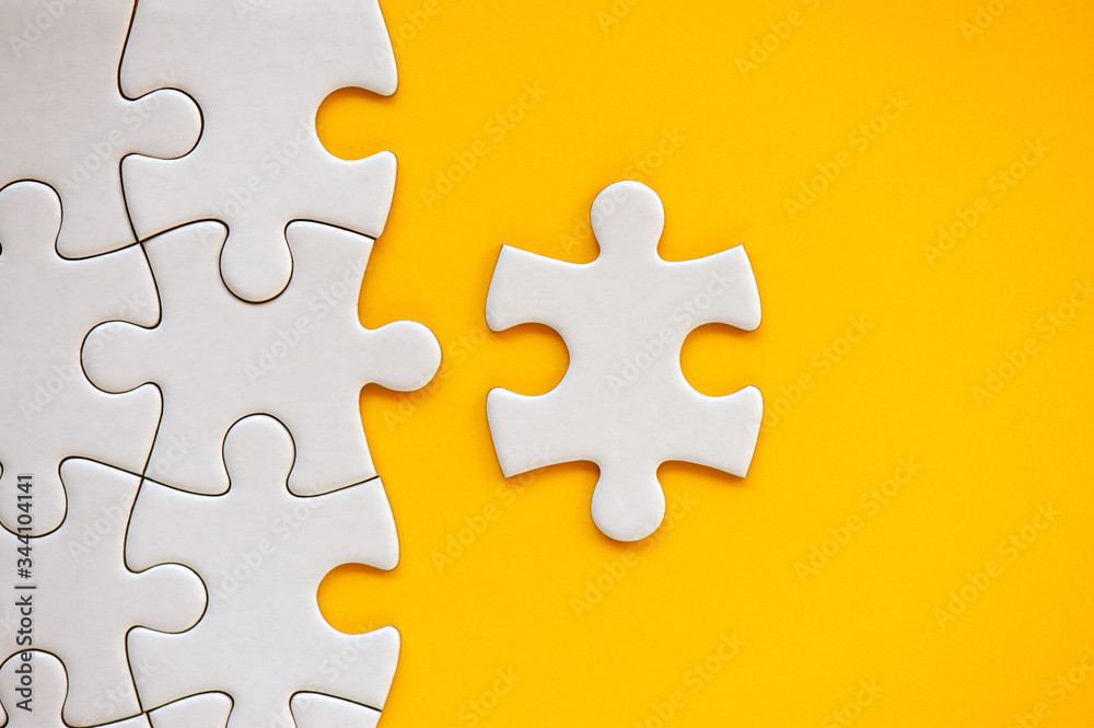 Puzzle pieces on orange background. White square puzzle pieces grid. Business background. Copy space for text, top view, close up. Puzzle pieces on orange background. White square puzzle pieces grid. Business background. Copy space for text, top view, close up.