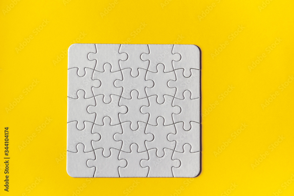Puzzle pieces on yellow background. White square puzzle pieces grid. Business background. Copy space for text, top view.