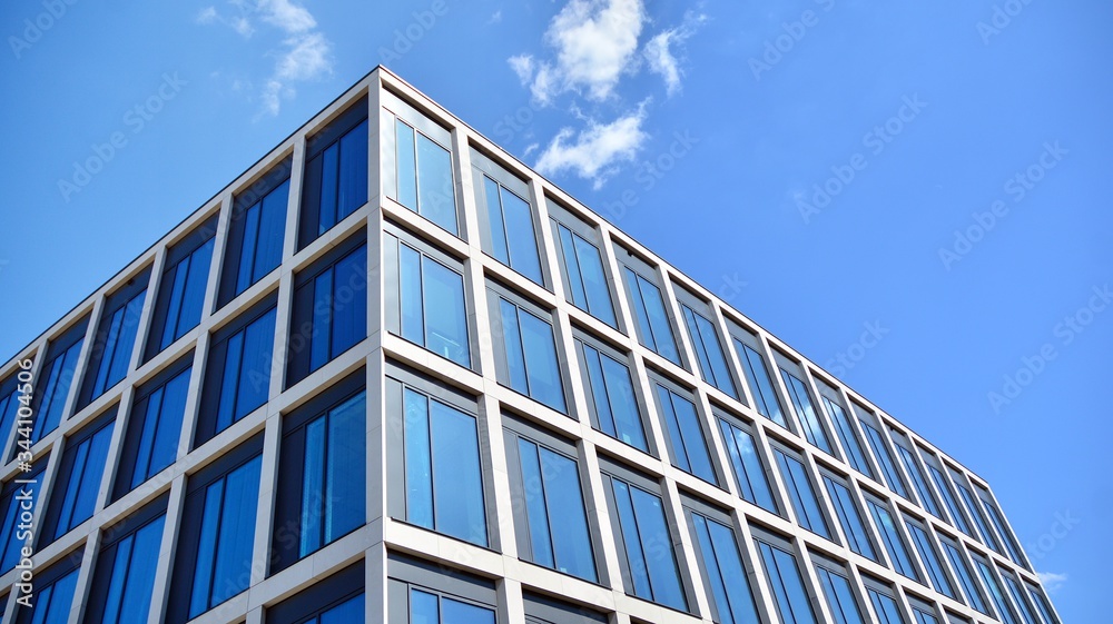 Modern office building windows with vertical lines and reflection. Building reflecting the sky with clouds and creating a surreal view. Modern office building windows with vertical lines and reflection. Building reflecting the sky with clouds and creating a surreal view.