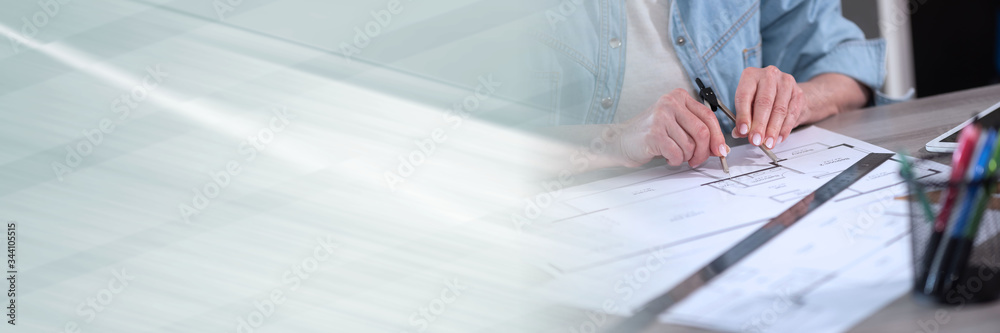 Female architect working on blueprint; panoramic banner Female architect working on blueprint; panoramic banner