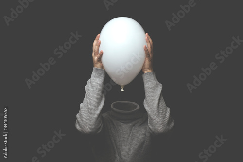 surreal man without head holding white balloon
