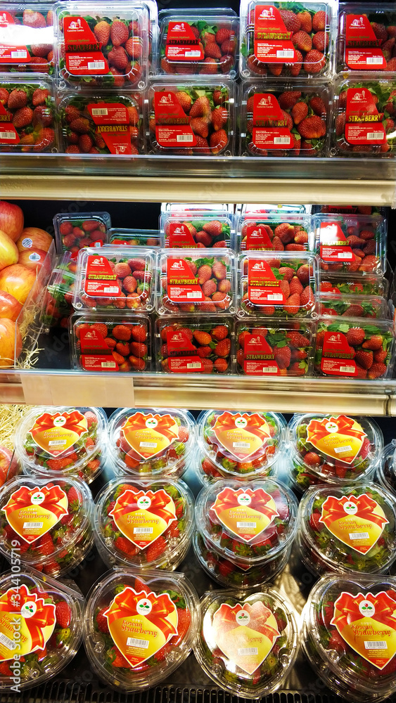 Strawberries in plastic boxes at the grocery store counter