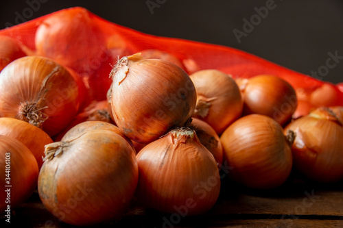 Fresh ripe onions on wood background.