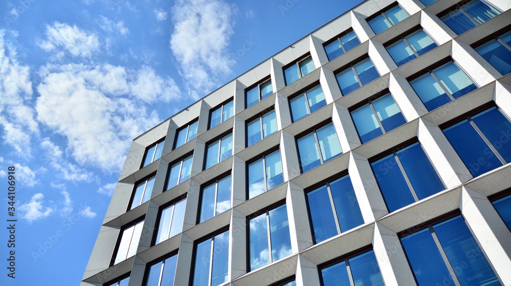 Modern office building windows with vertical lines and reflection. Building reflecting the sky with clouds and creating a surreal view. Modern office building windows with vertical lines and reflection. Building reflecting the sky with clouds and creating a surreal view.