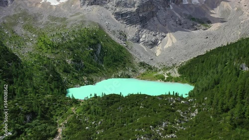 Lake Sorapis bright turqoise water in the Dolomites Italy, forward aerial photo