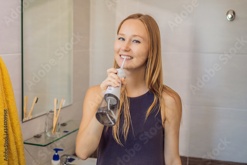 Woman using an oral irrigator in bathroom