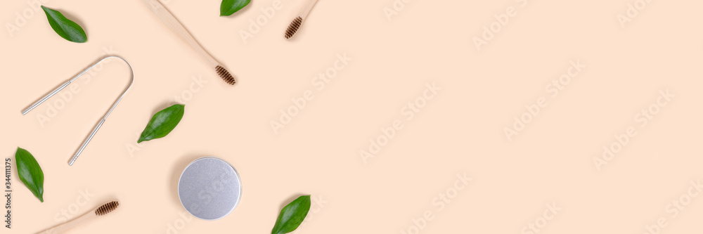 Banner with frame made of accessories for tooth hygiene and green leaves on a beige background. Plastic free concept with copy space. Banner with frame made of accessories for tooth hygiene and green leaves on a beige background. Plastic free concept with copy space.