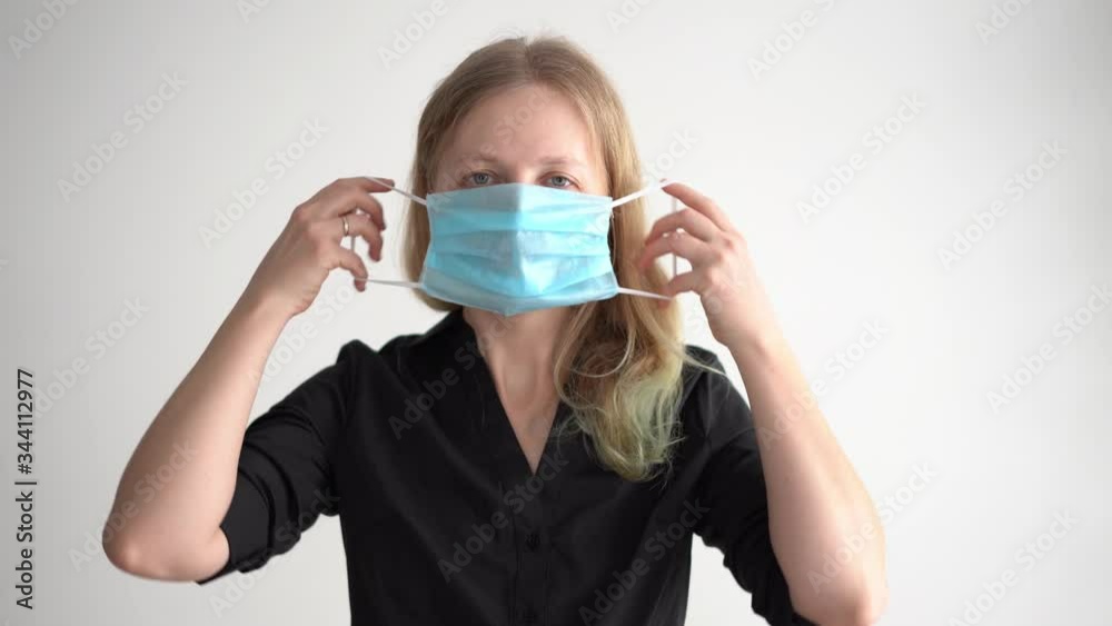protection against coronavirus. woman puts a mask on her face. protection against coronavirus. woman puts a mask on her face.