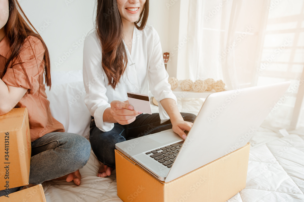 Young woman asian work from home online marketing currently ordering products for sale and delivery for customer. Business owner, SME, shipping, work from home(WFH), freelance, Start up concept. Young woman asian work from home online marketing currently ordering products for sale and delivery for customer. Business owner, SME, shipping, work from home(WFH), freelance, Start up concept.