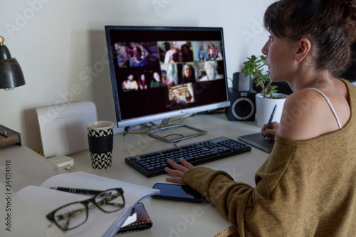 A young woman working at home. She is making a video call with the computer. Work remotely.