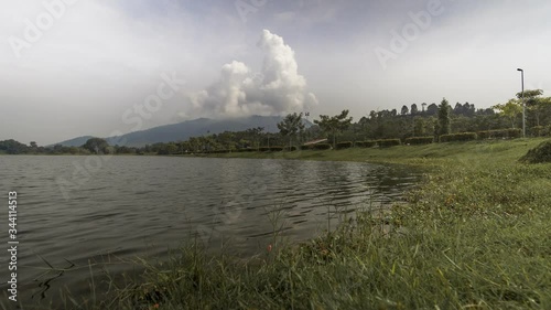 4K moving timelapse footage of a lake during the cloudy day with dramatic clouds movement at mountain top.