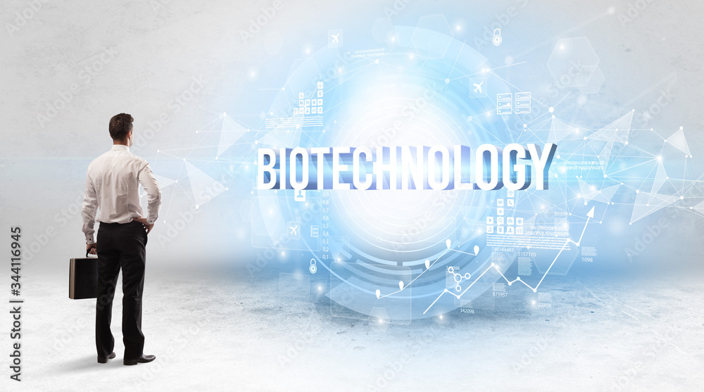 Rear view of a businessman standing in front of BIOTECHNOLOGY inscription, modern technology concept Rear view of a businessman standing in front of BIOTECHNOLOGY inscription, modern technology concept