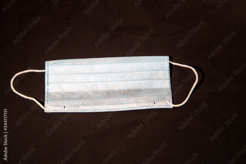 disposable medical mask lies on a brown table. medical mask from coronavirus covid-19 disposable medical mask lies on a brown table. medical mask from coronavirus covid-19