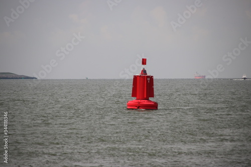 Red buoy as a waterway marking on the Nieuwe Waterweg canal in the port of Rotterdam photo