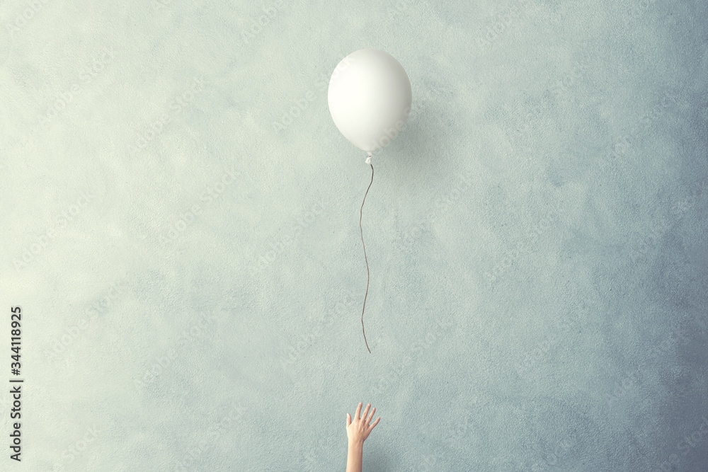 hand lets white balloon fly free - obrazy, fototapety, plakaty 