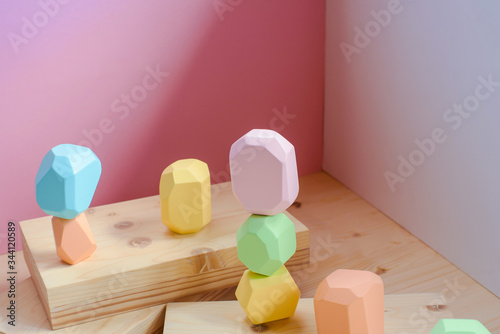 Abstract figures from elements of wooden tumi ishi pastel colors on a wooden podium on a paper background. photo