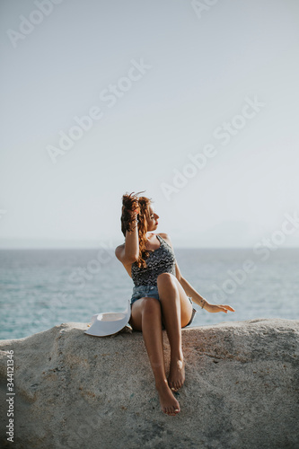 Young woman in bikini sitti...