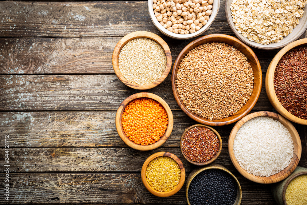 Organic products. Bowls with different gluten free grains on wooden background, top view Organic products. Bowls with different gluten free grains on wooden background, top view