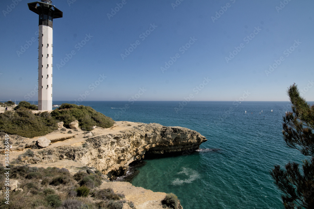Lighthouse in mediterranean with clear sky. Sunny day. Golden coast.