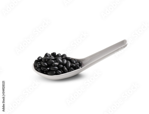 Black beans in white spoon on white background