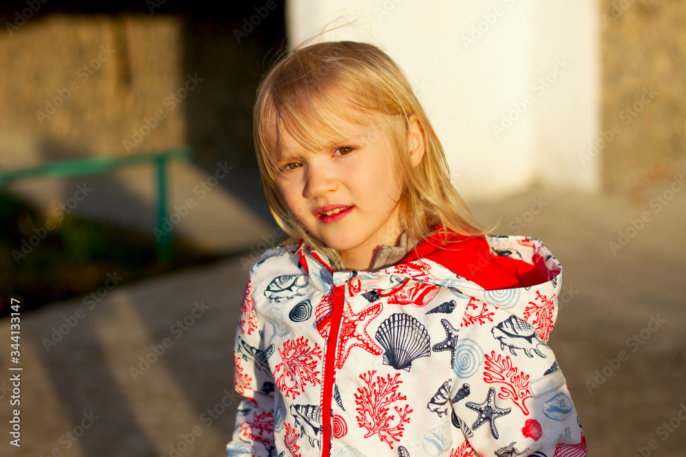 Portrait of a pretty blond girl wearing rain jacket on a beautiful sunset light Portrait of a pretty blond girl wearing rain jacket on a beautiful sunset light