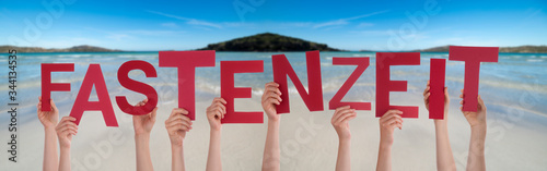 People Hands Holding Red German Word Fastenzeit Means Fasting. Ocean And Beach As Background