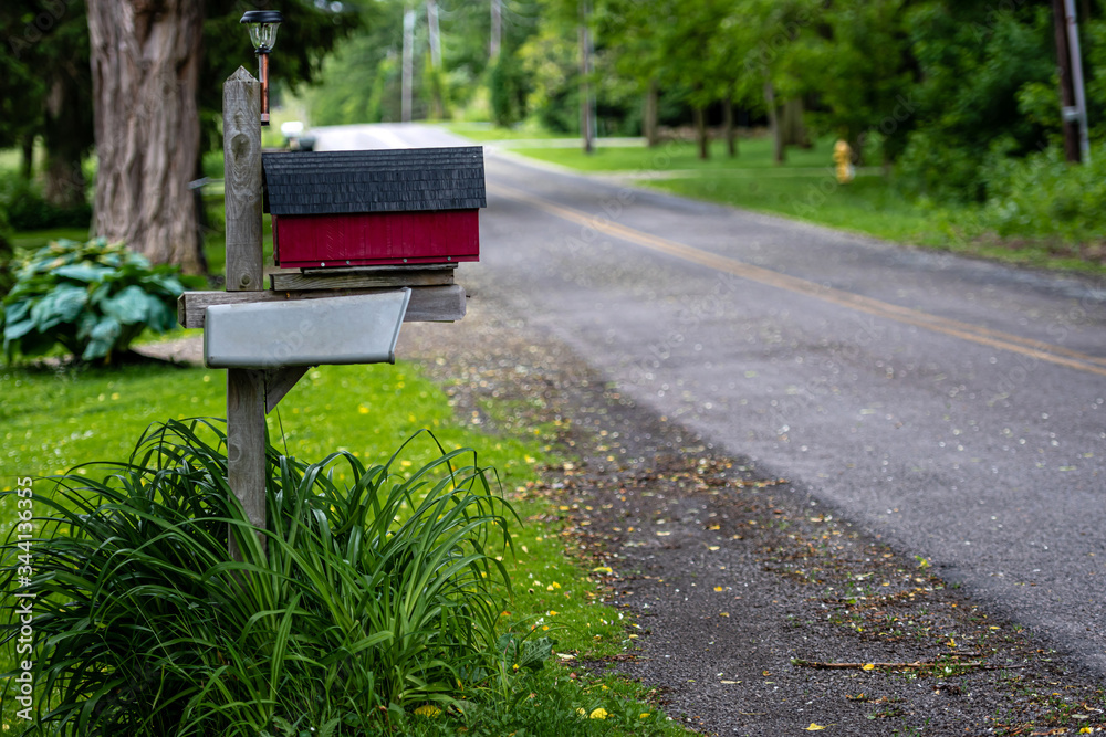a traditional American mailbox on the side of a village road a traditional American mailbox on the side of a village road