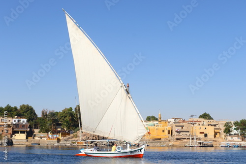 Traditional felucca sailing boat crossing Nile river at Aswan