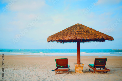 Fototapeta Naklejka Na Ścianę i Meble -  Two sun loungers and umbrella on the beach