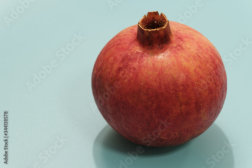 red pomegranate on blue color background isolated view