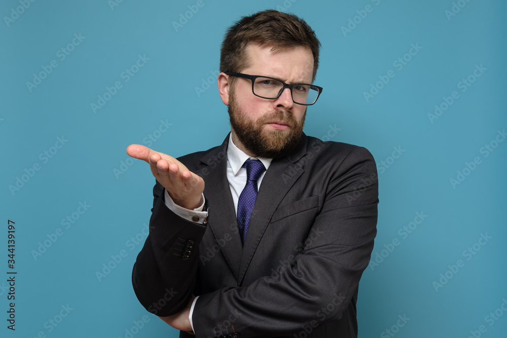 Business man in a suit is bewildered, he strictly looks at the camera and makes a questioning gesture with hand. Business man in a suit is bewildered, he strictly looks at the camera and makes a questioning gesture with hand.