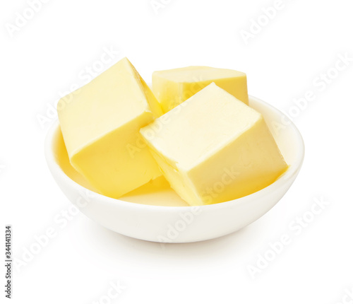 Butter pieces in white bowl isolated on white background. Butter cubes.