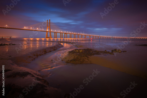 Famous cable-stayed Vasco da Gama bridge over Tagus river during morning blue hour, Lisbon Portugal