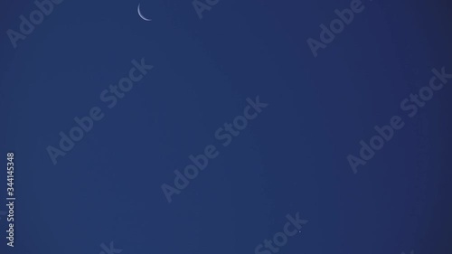 Young Moon and Venus on a dark night sky. photo