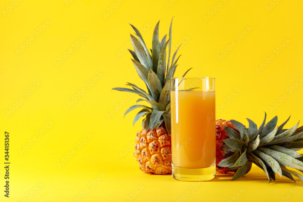 Fresh ripe pineapples and juice on a yellow background. Fresh ripe pineapples and juice on a yellow background.