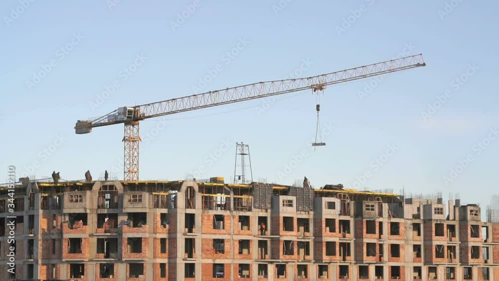 Building large complex in winter. Builders work on the construction site. Construction vehicles outdoors Building large complex in winter. Builders work on the construction site. Construction vehicles outdoors