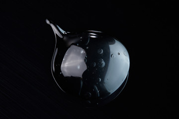 Transparent gel cream texture with a black background.