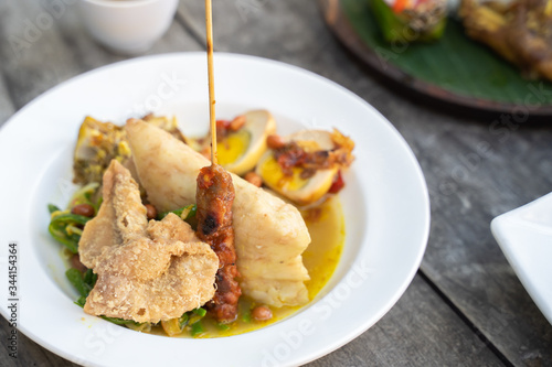 lontong opor. chicken with curry soup served with ketupat or rice cake