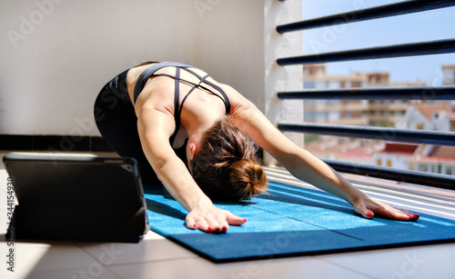 Woman perform yoga asana on terrace at home