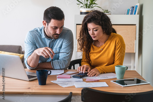 Young couple calculating their domestic bills at home stock photo