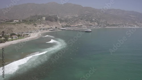 Aerial shot of beautiful ocean against mountain range in city, drone moving over sea - Malibu, California photo