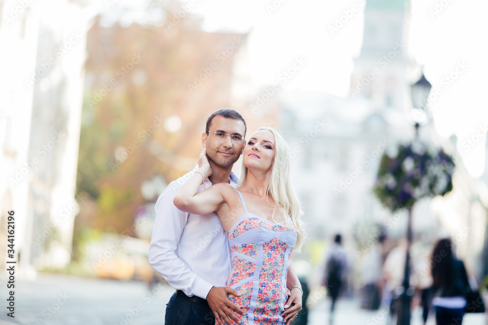 Fototapeta premium walking down the street together. Happy young man and smiling woman walking through the streets of Old Town,