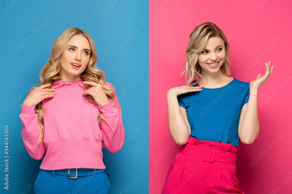 Smiling blonde sisters looking away on pink and blue background Smiling blonde sisters looking away on pink and blue background