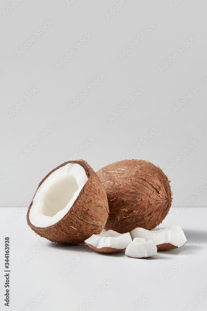 Set from natural ripe coconut fruits with half and pieces on a grey background.