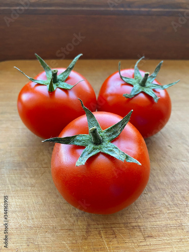 Obraz na płótnie Branch of three fresh red tomatoes. w salonie