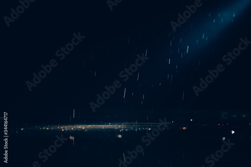 Abstract images of pouring rain in the night. © belyaaa
